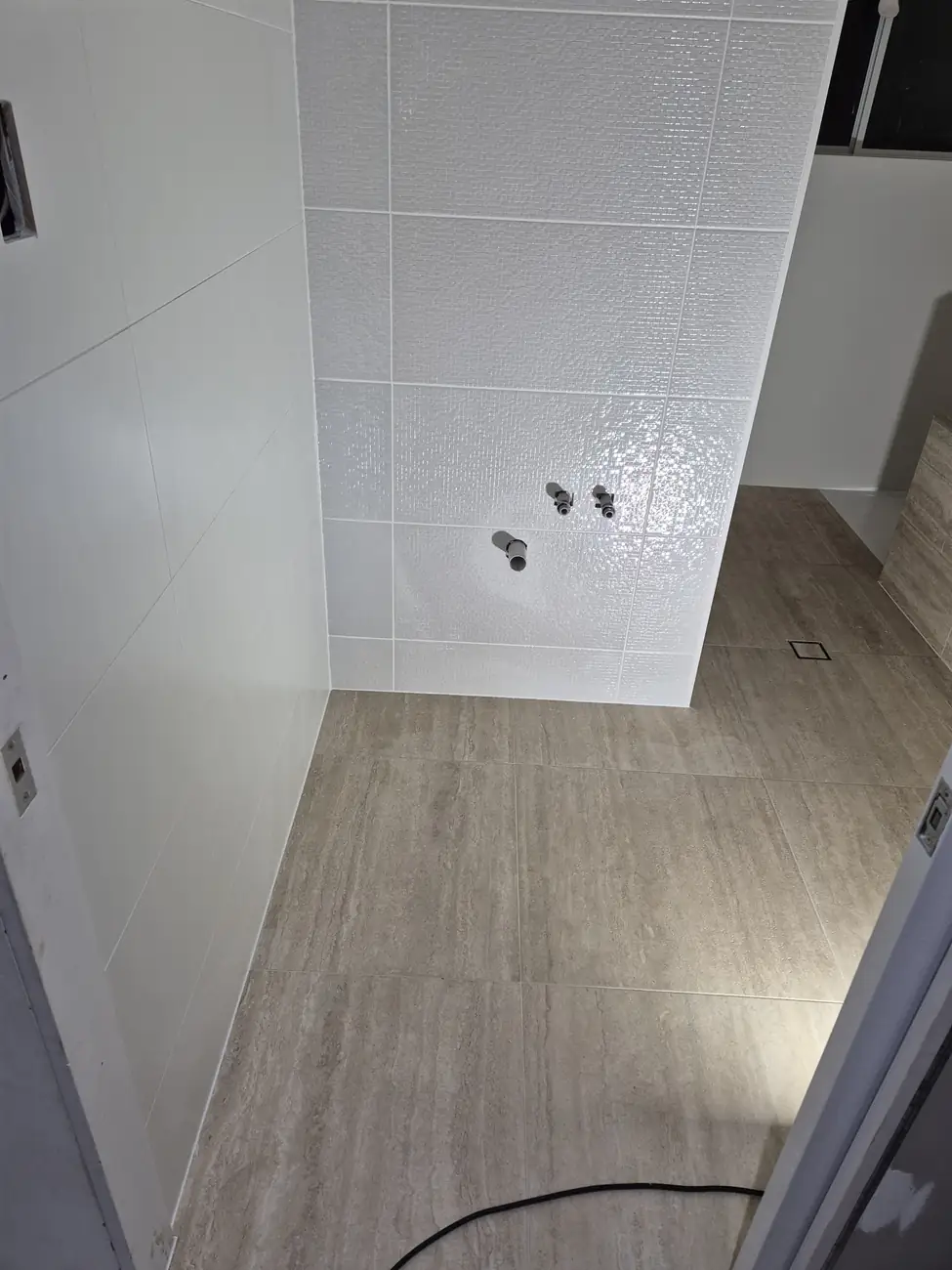 White gloss wall tiles meeting the timber-look floor